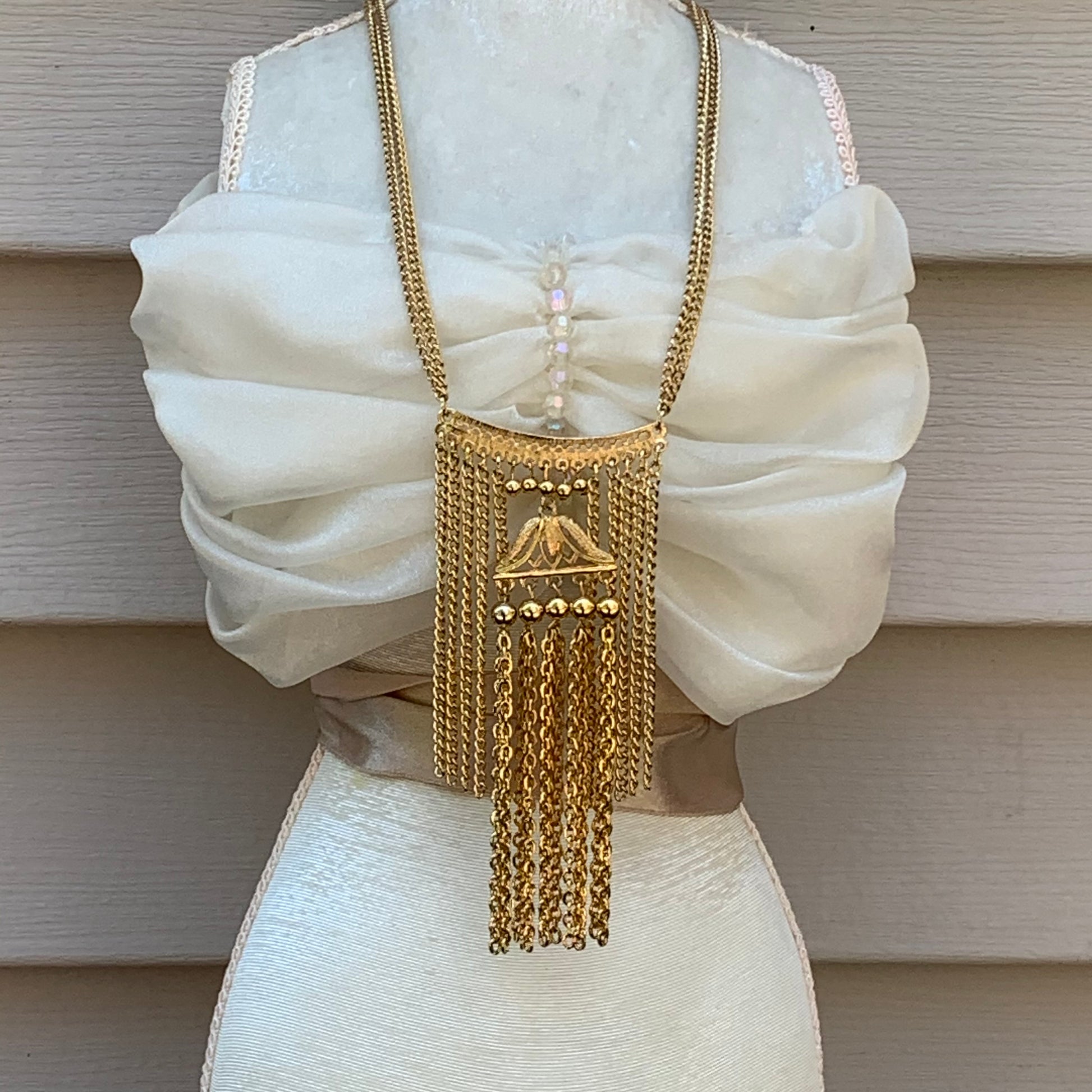 Layers of vintage chain with a pagoda pendant in the center. 