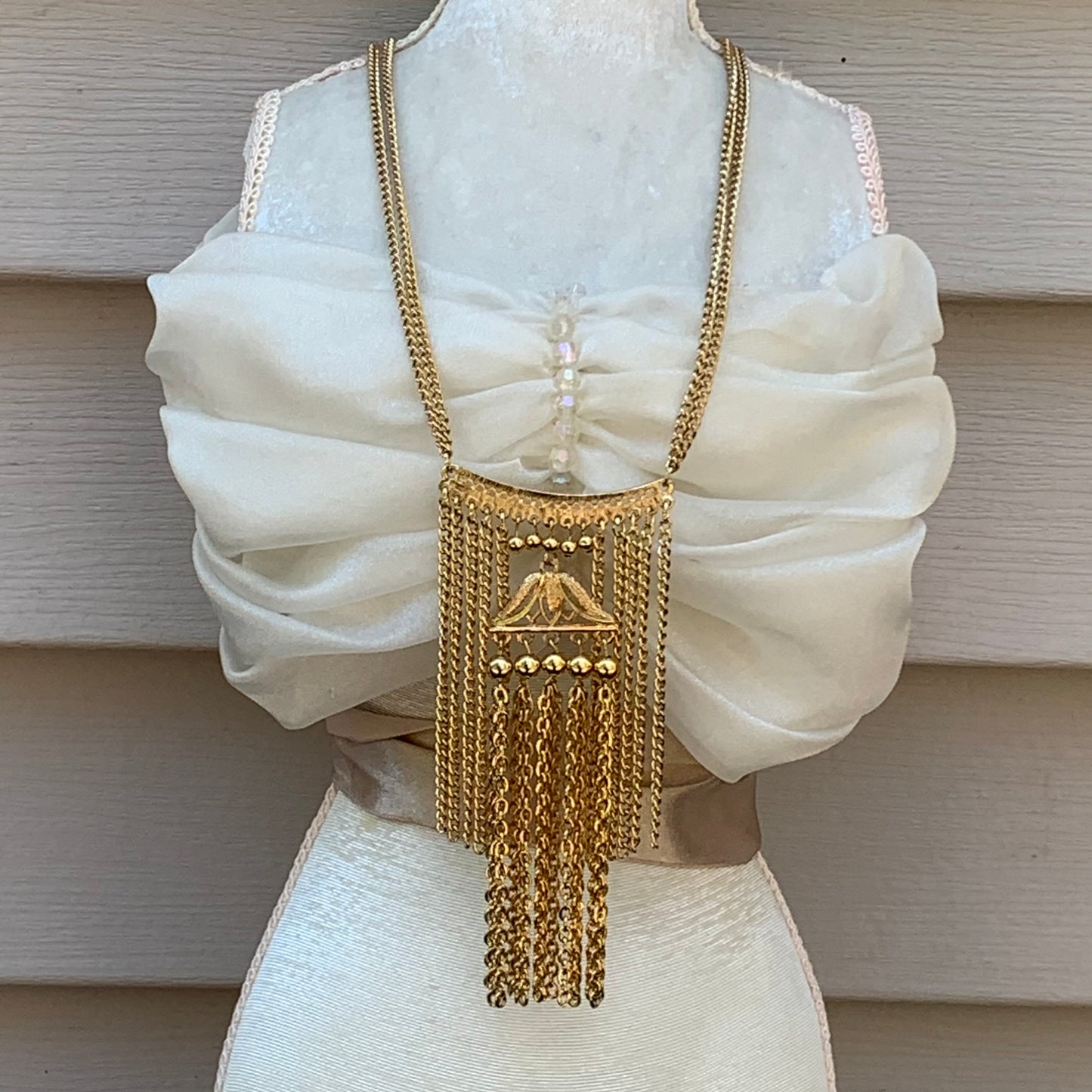 Beautiful gokd tone metal necklace with long strands of chain forming this vintage pendant necklace.